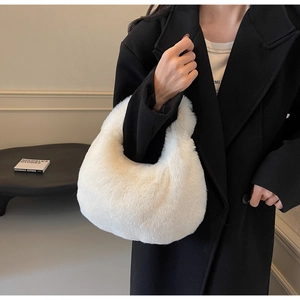 Sac croissant en fausse fourrure blanc crème porté avec un manteau noir élégant d'automne