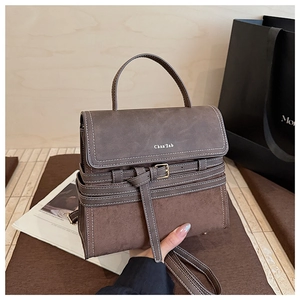 Close-up of vintage messenger bag with coffee leather and suede flap details