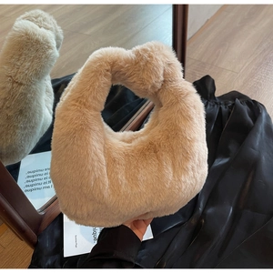 Gros plan détaillé du sac à main peluche abricot avec poignée nouée et texture douce