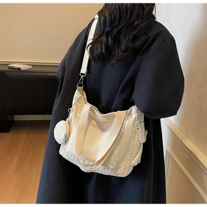 Detail of cream canvas tote bag with adjustable shoulder strap and small round coin purse