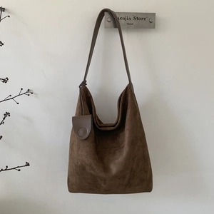 Detail view of large dark brown suede hobo bag with matching leather coin purse accessory