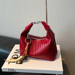 Macro detail of red woven leather texture with wooden bead tassel and silver buckle