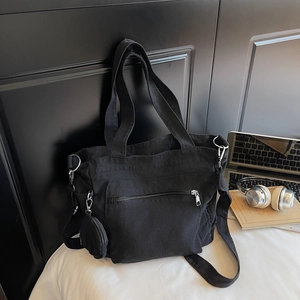 Détail du sac cabas en toile noire avec poche zippée et petit étui rond attaché