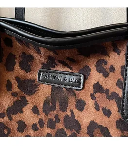Close-up of leopard print tote bag fabric with leather trim and fashion logo label