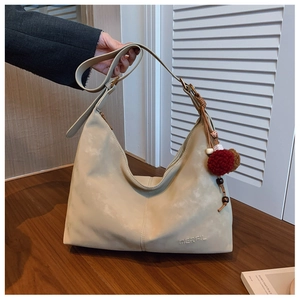 Detail der Retro-Struktur-Halbmond-Tasche mit verstellbarem Gurt und Dekorativem Anhänger
