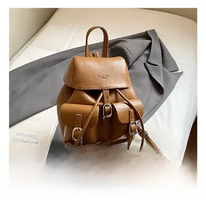 Close-up of vintage brown PU leather backpack with pebbled texture and buckle pockets