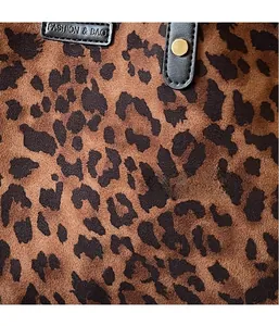Detailed close-up of leopard print faux suede fabric with gold studs and logo strap