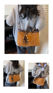Detailansicht braune Wildledertasche mit Rautensteppung und Holzperlen-Quaste