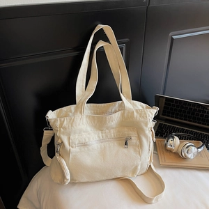 Détail d'un grand sac fourre-tout en toile blanc cassé avec porte-monnaie latéral