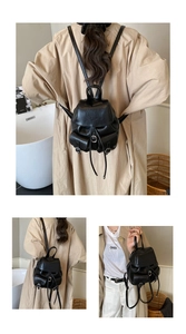 Detail showing high-quality black leather texture and vintage drawstring closure of the backpack