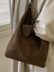 Minimalist deep brown suede tote bag with slim shoulder straps and top knot detail