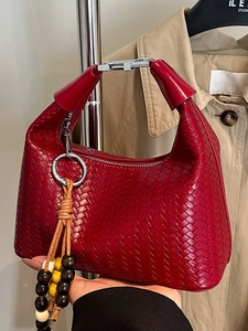 Red woven leather hobo handbag with silver metal buckle and wooden bead tassel detail