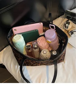 Interior view showing large capacity storage for tablets and bottles in leopard tote bag