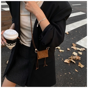 Street style προβολή μιας micro καφέ σουέτ τσάντας με μακρύ λουράκι και διακοσμητική χάντρα