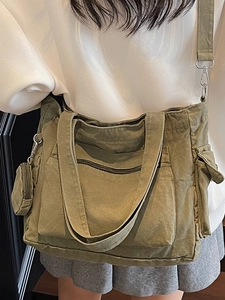 Sac fourre-tout en toile olive avec poches multiples et bandoulière sur le mannequin