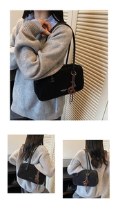Detail of black suede shoulder bag with MIKAXIOI logo and decorative knot pendant