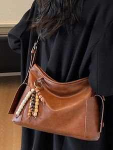 Brown minimalist soft leather hobo bag with colorful wooden bead tassel and side pocket
