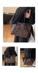 Close-up of leopard print canvas tote bag with black leather handles and gold studs