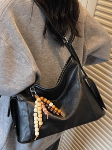 Black minimalist pleated leather shoulder bag with ethnic beaded tassel and strap