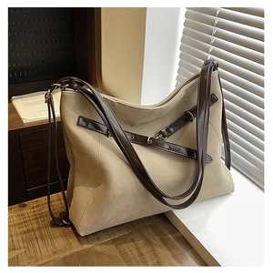Détail du grand sac cabas en daim beige avec sangles marron et œillets métalliques