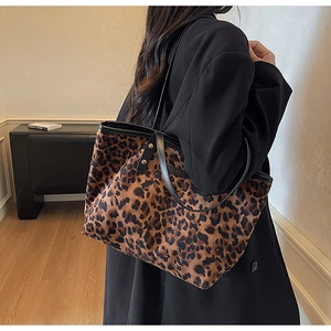 Detailed view of large leopard print tote bag with black straps on a fashion model