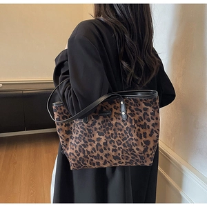 Close-up of leopard print tote bag texture with leather shoulder strap and rivet