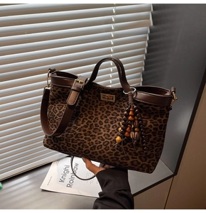 Detail der Leopard-Tasche mit goldenem Drehverschluss und Quaste aus Holzperlen-Anhänger