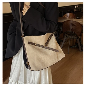Détail du grand sac fourre-tout en daim beige avec lanières marron et boucles dorées
