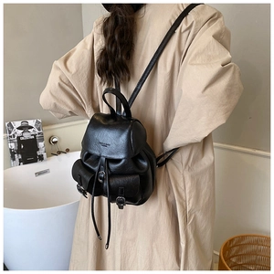 Litchi pattern leather mini backpack with flap pockets and drawstring closure on model