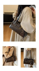 Détail du sac rétro chocolat avec boucle dorée et accessoire en forme de bretzel chic