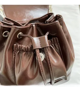 Close-up of the dark brown leather drawstring and metal eyelet detail of the backpack