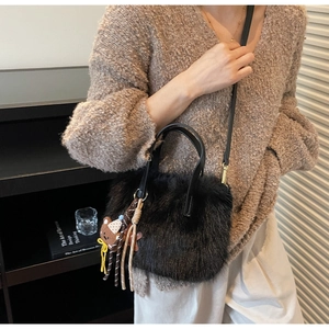Détail du sac à bandoulière en fausse fourrure avec poignées en cuir et charm ourson