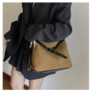 Détail du sac bandoulière en daim avec sangle en cuir et boucles de style vintage