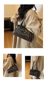 Détail du sac bandoulière vintage gris foncé avec pendentif bretzel et anneaux métal