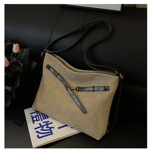 Gros plan d'un sac cabas en daim beige avec lanières en cuir marron et boucles en bronze