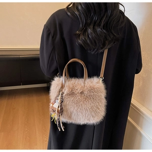 Vue détaillée d'un sac bandoulière en peluche marron clair avec charm ours sur un modèle