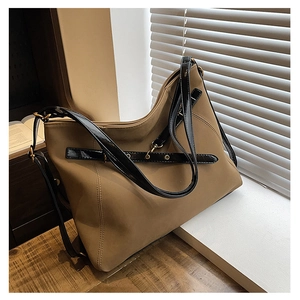 Détail du sac fourre-tout en daim kaki avec bandoulières vernies et boucles dorées
