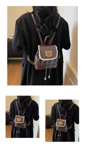 Detail of mini dark brown leather backpack featuring a cute bear patch and lace trim