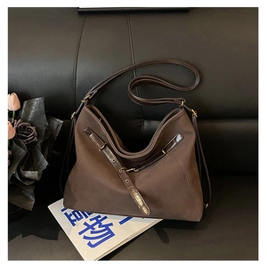 Détail de sac cabas en suédine marron foncé avec boucles métalliques dorées élégantes