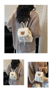 White bucket backpack with lace trim and brown plush bear patch detail showing carry styles