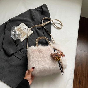 Détail du sac à main en peluche rose avec texture douce et breloque ours mignon