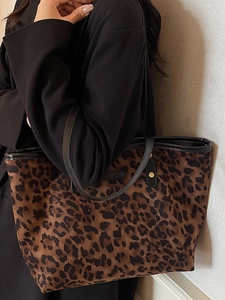 Chic leopard print tote bag with black leather straps and golden metal hardware details