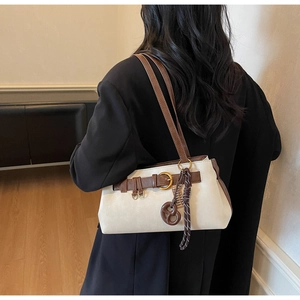 Sac à bandoulière chic crème et marron avec boucle et breloque biscuit sur le modèle
