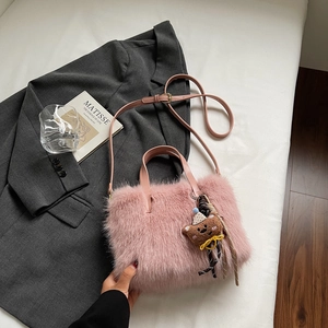 Détail du sac à bandoulière en fausse fourrure rose avec breloque ours et sangle en cuir