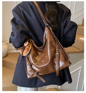 Detail of dark brown Hobo tote bag with adjustable metal buckle and soft donut pendant