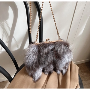 Détail d'un sac à main en fausse fourrure argentée avec chaîne dorée et fermoir rétro