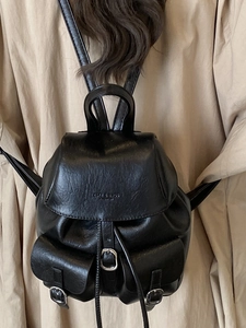 Fashionable black faux leather backpack with flap closure and multiple front pockets