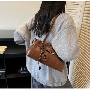 Détail du sac sous le bras vintage marron foncé avec boucle dorée et décor de foulard