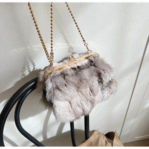 Détail du sac seau en fausse fourrure gris clair avec cadre doré et bandoulière chaîne