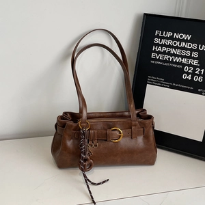 Détail du sac sous le bras marron caramel avec double bandoulière et anneaux dorés